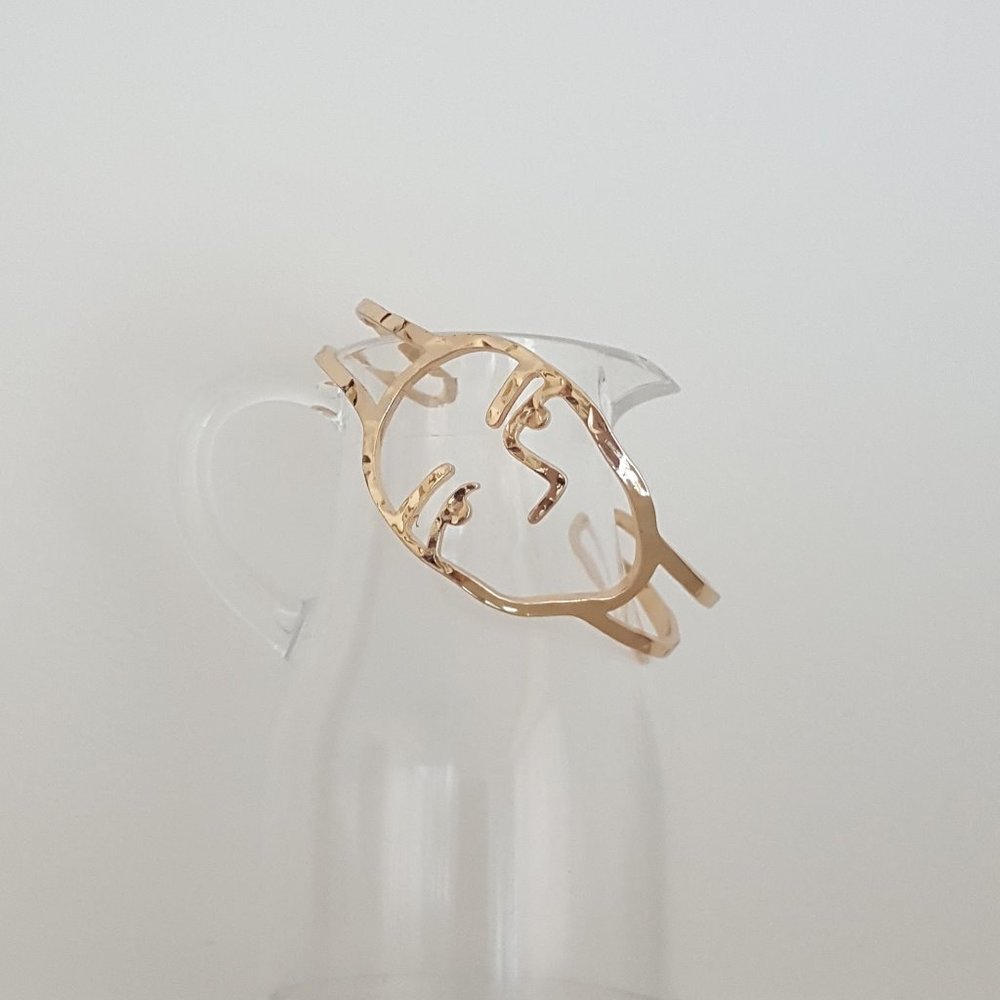 Gold tone bangle cuff - face motif